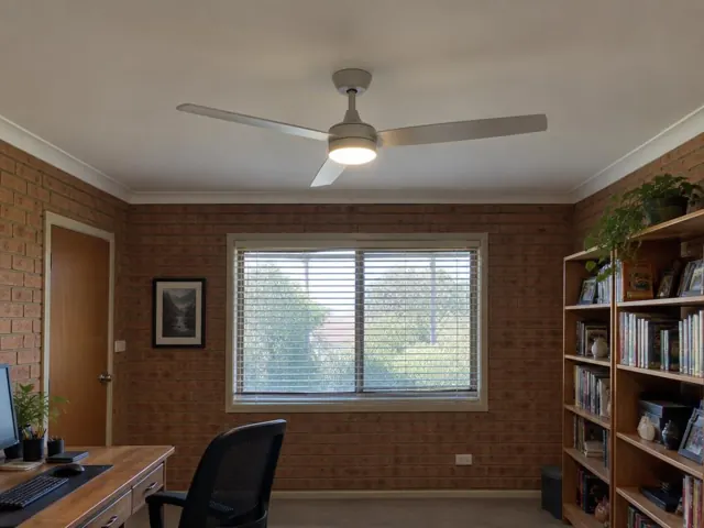 Ceiling fan with light in a brick home office with window, shelves and desk in New Lambton Heights